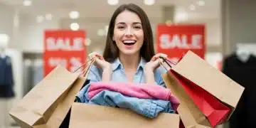 Woman happily showing off her discounted end-of-season apparel purchases.